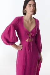 Vestido midi fucsia de lino, con escote en V, mangas largas abullonadas, lazos frontales y tajo lateral.