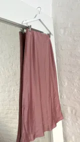 Pollera midi de seda color rosa, con cintura elástica.