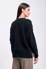 Buzo de tejido de punto negro, con cuello redondo y manga larga, de calce holgado.