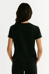 Remera blanca de algodón con estampado de flores azules y naranjas, de corte clásico y cuello redondo.