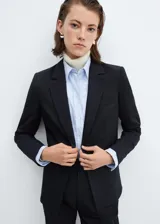 Blazer negro entallado con solapas de muesca, hombros estructurados, abertura posterior y dos bolsillos de ribete delanteros.