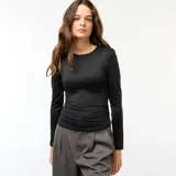 Camiseta negra cropped de manga larga con efecto arrugado en los laterales.