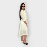 Vestido camisero midi negro con cuello clásico, mangas 3/4 y falda acampanada. Presenta un cinturón de lazo en la cintura y cierre frontal con botones.