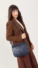 Bandolera color tostado con tapa y broche, bolsillo principal y bolsillos internos organizadores, cierre trasero y correa larga regulable.