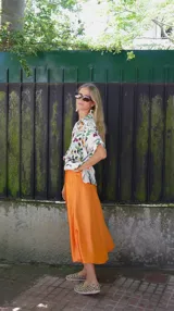 Falda midi evasé de raso color negro, con cintura elástica y cinturón con apliques metálicos.