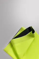 Par de manguitos de running color amarillo flúor, confeccionados en tejido técnico elástico, con banda de silicona en el borde superior y logo estampado.
