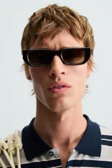 Polo de hombre corte holgado con cuello solapa y cierre de botones. Diseño a rayas horizontales grises y azul marino.