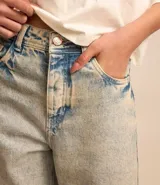 Pantalón recto de jeans con efecto sobretinto, trabillas en la cintura, cierre con botón y cremallera, bolsillos delanteros y traseros.