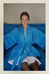 Kimono turquesa de camisería con cuello mao, pretina ajustable y desmontable, y bolsillos laterales invisibles.