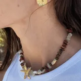 Aros tipo botón dorados con textura irregular que simula la superficie de un molusco.