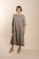 Vestido largo debajo de la rodilla, acampanado, color marrón, con cuello bote, bolsillos en el corte y mangas 3/4.