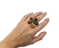 Anillo dorado con aplique de flor de resina tipo carey, de tamaño regulable.