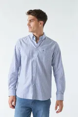 Camisa oxford celeste con rayas verticales blancas, de manga larga y corte regular. Tiene cuello abotonado, bolsillo en el pecho y logo bordado.