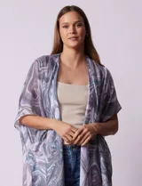 Kimono tejido con estampado abstracto en tonos grises y blancos, con mangas cortas y terminación de ruedo con borlas negras.