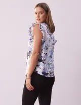 Blusa de algodón estampada con flores en tonos celeste y azul, marca Cable & Gauge. Cuello a la base, escote en V y abertura central con botones. Sisa con volados.
