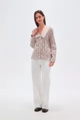 Camisa de algodón con estampado de rayas verticales en tonos beige y marrón. Presenta un cuello solapa con detalle de volados, cierre frontal con botones y mangas largas.