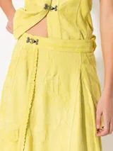 Falda midi color beige de gamuza arrugada, corte irregular y diseño tipo portafolio.