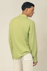 Camisa de manga larga color verde claro, confeccionada en tejido de lino y viscosa, con botones de madera y parche con logo.