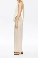 Pantalón corte jogger color beige, con largo tobillero, bolsillos tipo alforja y logo bordado. Cintura elástica ajustable con cordones.