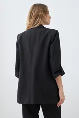 Blazer color crudo de corte recto, con cuello solapa, mangas 3/4 con botón y bolsillos frontales.
