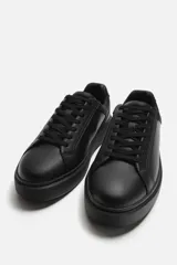 Zapatilla de cordones monocolor negra con suela con volumen.