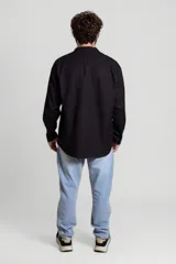 Camisa blanca de cuello mao y mangas 3/4 con botón para sujetar.