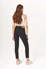 Pantalón jean negro de tiro alto, corte mom y largo al tobillo.