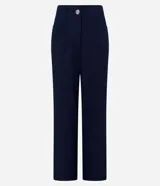Pantalón de vestir azul marino, de corte recto, con bolsillos laterales y traseros. Se ajusta a la cintura con cinturón de cuero marrón.