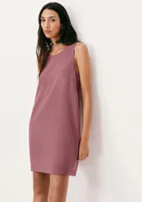 Vestido corto sin mangas color beige, de corte recto y cuello redondo.