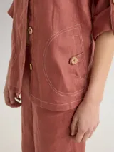 Camisa color coral de lino, corte holgado, escote redondo y mangas 3/4 ajustables con botón.
