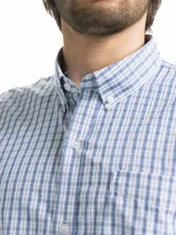 Camisa de hombre de manga corta con estampado a cuadros en tonos blanco, verde y marrón. Tiene cuello abotonado y bolsillo en el pecho.