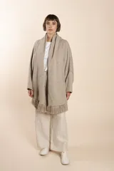 Saco de lana color marrón claro, con mangas amplias, cuello tipo bufanda con flecos y bolsillos laterales. Diseño oversize sin forro.