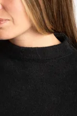 Sweater de punto color negro confeccionado en mezcla de lana lambswool y nylon. Presenta cuello alto tipo polera, manga larga y terminaciones acanaladas en puños y bajo.