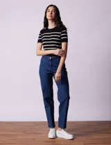 Jean elastizado de corte recto, color azul denim, con pretina con pasadores, botón y cierre. Tiene tres bolsillos delanteros y dos bolsillos traseros.