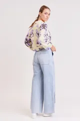 Pantalón de jean celeste de corte ancho, estilo cargo, con bolsillos laterales con solapa y detalle de costuras reforzadas.