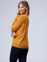 Polera de punto fino marca Nienty, color blanco, con cuello alto volcado y mangas largas con detalle de tajo en los puños.