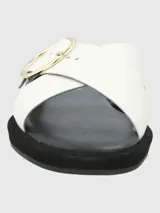 Sandalias de cuero sintético color blanco, con dos tiras anchas cruzadas sobre el empeine y hebilla circular dorada. Plataforma plana color negro.