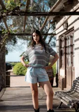 Remera de hilo tejido a rayas horizontales color beige y negro, de mangas cortas y corte suelto.