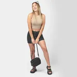 Cartera bandolera color beige con diseño acolchado y correa larga negra regulable.