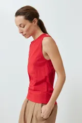 Musculosa roja de algodón con cuello redondo y botones decorativos en los hombros.