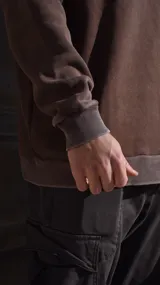 Buzo marrón de algodón con cuello redondo y puños y cintura acanalados.