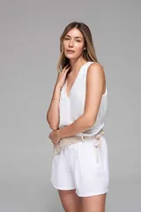 Short blanco de tela liviana con textura, cintura elastizada y bolsillos laterales.