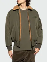 Chaqueta bomber verde militar con cuello de piel sintética color marrón, cierre frontal con cremallera, bolsillos laterales con solapa y bolsillo con cremallera en la manga izquierda.