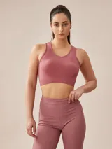 Top deportivo gris oscuro con espalda deportiva y banda elástica en el bajo busto.