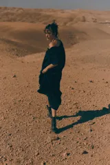 Vestido largo negro con escote cuadrado, cordón ajustable con borlas de cadena, mangas cortas abullonadas con forro y ribete elástico oculto, y costura fruncida bajo la cadera.