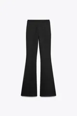 Pantalón negro de tiro alto confeccionado en tejido de punto elástico y flexible con trama compacta, mullida y opaca. Bajo acampanado.