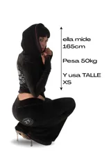Conjunto deportivo negro de terciopelo con ribetes rosados, compuesto por un hoodie crop con cierre y un pantalón de corte amplio con estampado de logo en la pierna.