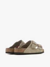 Sandalias Birkenstock Arizona de cuero gamuzado color topo, con dos correas ajustables con hebillas metálicas color cobre y plantilla anatómica de corcho y látex.
