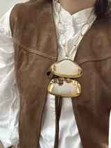 Collar dorado con cadena de eslabones grandes y doble dije de nácar irregular con borde dorado.