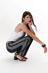 Pantalón de jean azul con paneles en distintos tonos de azul y marrón, corte recto y terminación desflecada.